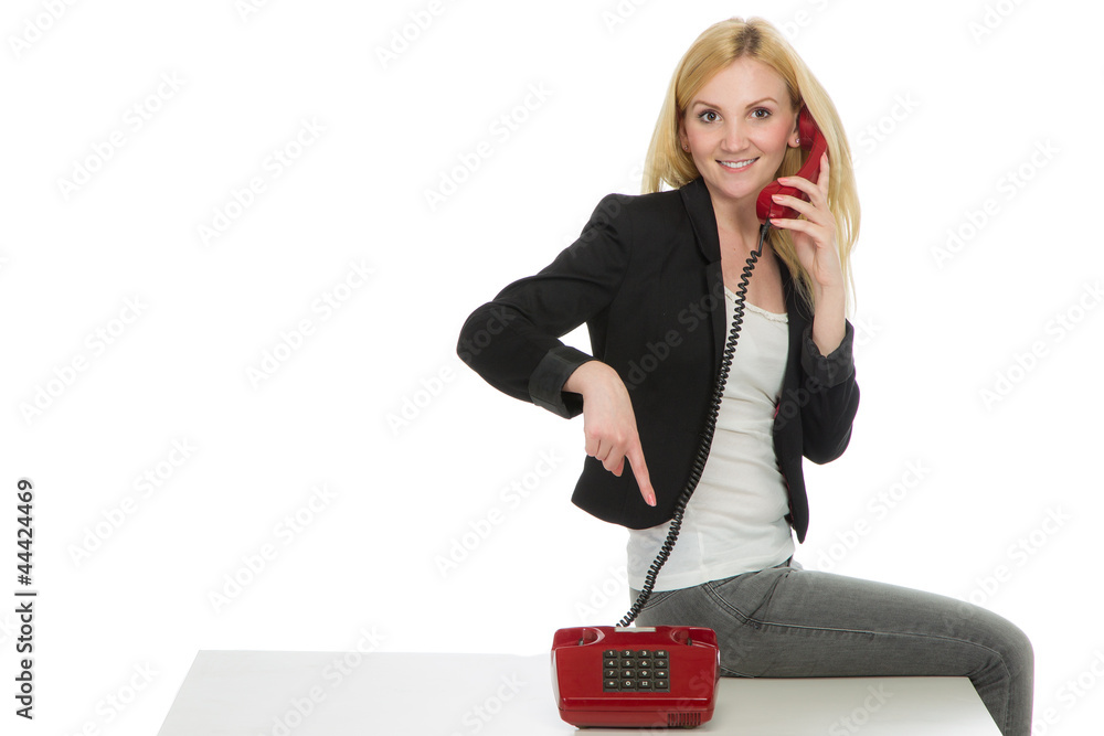 Junge Blonde Frau Sitzt Auf Dem Tisch Und Zeigt Auf Telefon Stock Photo Adobe Stock