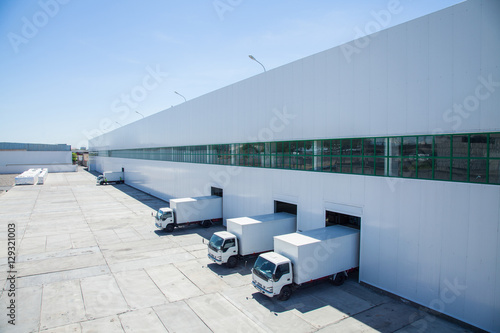 facade of an industrial building and warehouse with freight cars in length