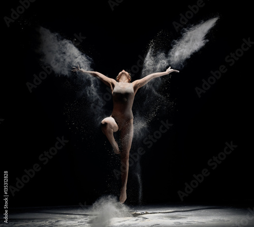 Slender girl dancing in white powder cloud