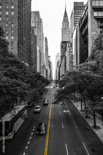 Endless streets of Manhattan New York skyscraper cars yellow lane marking black and white