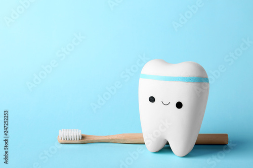 Model of tooth with happy face, brush and space for text on color background
