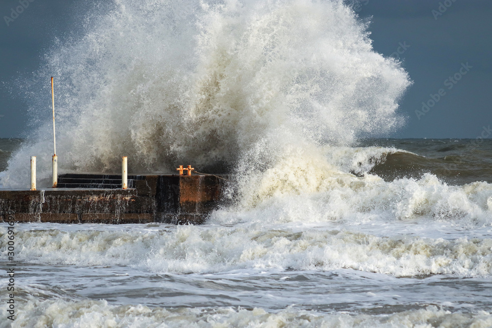 Breakwater And Harbour In Stormy Weather With Huge Waves Crashing Over