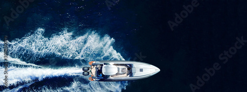 Aerial drone ultra wide top down photo with copy space of luxury rigid inflatable speed boat cruising in high speed in Aegean deep blue sea, Greece