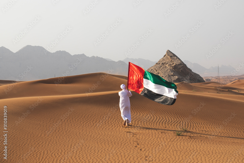 Arab Man Holding The Uae Flag In The Desert Celebrating Uae National