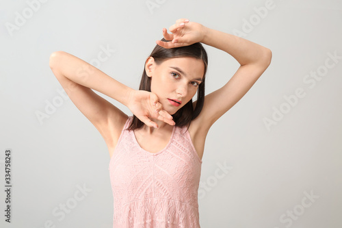 Young woman with beautiful makeup on light background