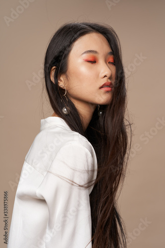 Pretty woman of Asian appearance makeup luxury charm beige background