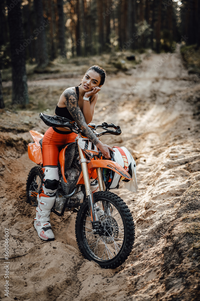 Beautiful Female Racer Wearing Motocross Outfit With Semi Naked Torso Sitting On Her Bike In The