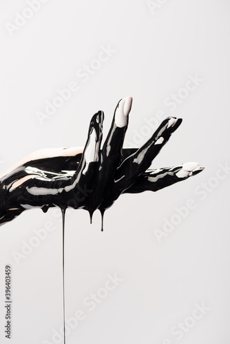 Cropped view of hand with dripping black paint isolated on white, stock image