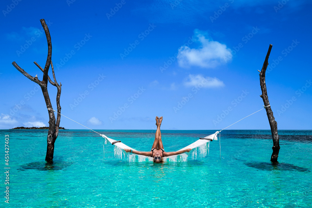 Elegant Sexy Woman In The White Bikini On The Sun Tanned Slim And Shapely Body Is Posing On