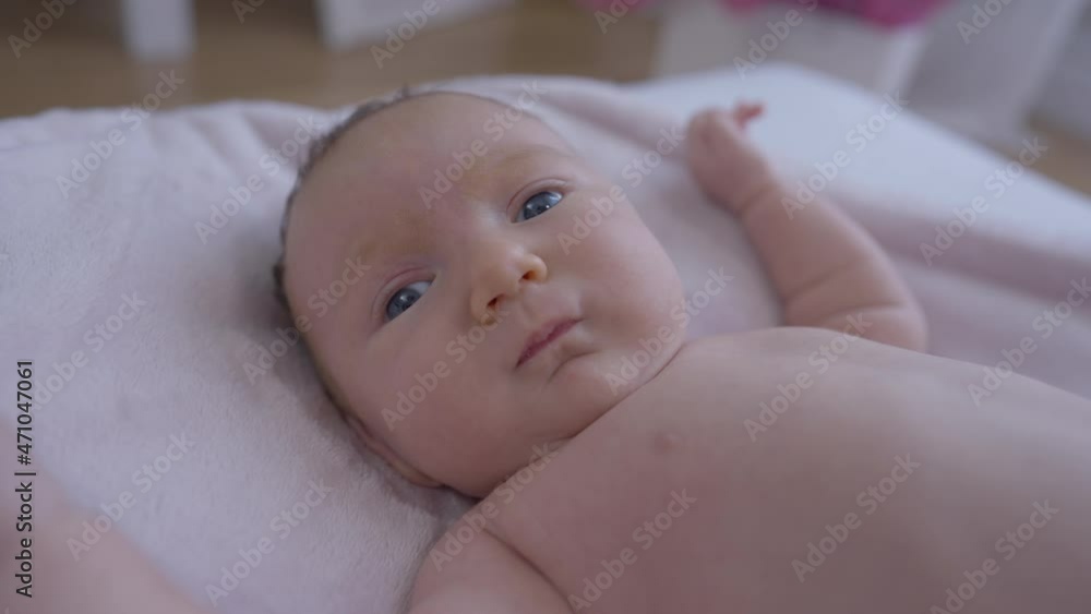 Portrait Of Curios Newborn Baby Girl Looking Away Start Crying Naked