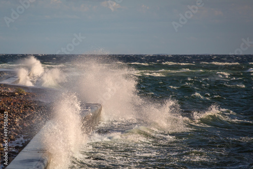 Piękne morze Bałtyckie, duże fale rozbijające się o brzeg skał, falochrony i mola. Spacer brzegiem plaży latające mewy, statki pasazerskie.