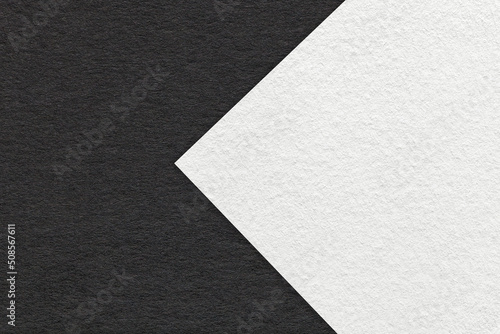 Texture of black and white paper background, half two colors with arrow, macro. Structure of dense craft cardboard.