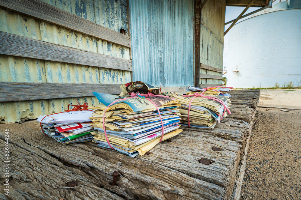 Piles Of Old Newspapers Tied Up With String Sitting On The Weather