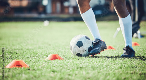 Soccer player, feet and ball with training cone on a field for sports game and fitness. Legs or shoes of male football or athlete person outdoor for agility exercise, performance or workout on grass