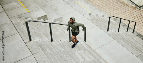 Fitness, city and black man running on stairs outdoor, exercise and training healthy body in urban town top view. Sports, cardio and African athlete on steps for workout, energy and jog for wellness