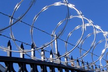 Barbed And Razor Wire On Top Of Fence