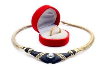 golden necklace and a ring against white backgroun