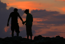 Silhouette Of Couple Walking In Front Of Sunset