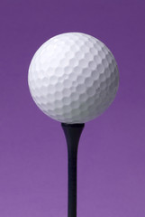 Wall Mural - golf ball on blue tee, purple background