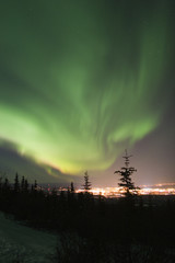 Wall Mural - active aurora borealis in the sky over town lights