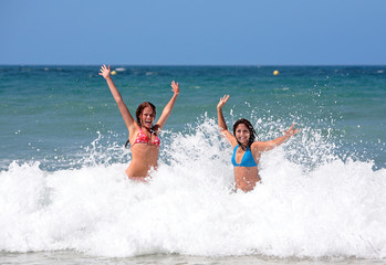 two attractive young girl friends playing in the s