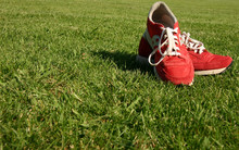 Red Running Shoes On A Sports Field