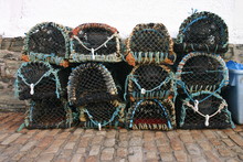 Lobster Pots Stacked At Mullion Cove, Cornwall, Uk