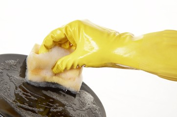 hand in yellow rubber glove with yellow sponge and