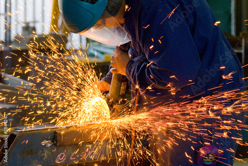 Fotografía men at work grinding steel