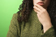 © iofoto - caucasian woman with hand on chin wearing green clothing.