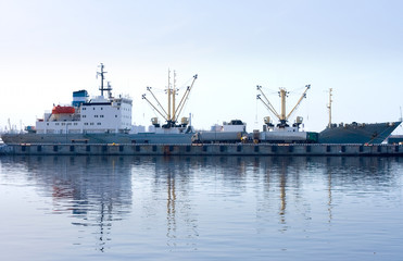 container ship and trucks between water and sky