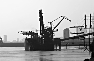  silhouette of cargo ship unloading