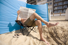 Man Reading His Paper At The Beach