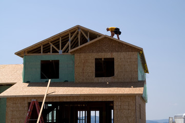 worker on roof of new home