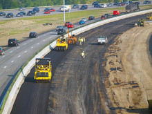 Workers Laying Asphalt In Freeway Construction Zone