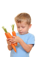 Wall Mural - three years old boy and fresh carrot isolated on white