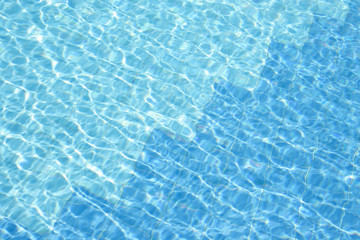 blue water of swimming pool at sunny day .