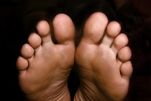 Pair Of Feet On The Black Background