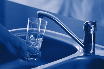 Pouring Fresh Tap Water Into a Glass. Shallow DOF. Focus on Tap.