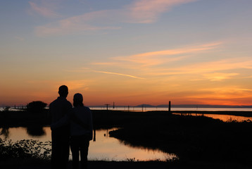 Wall Mural - young couple on the beach at sunset