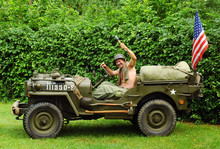 Man In Military Style In Old Fighting Jeep 