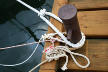 Different Ropes Tied To A Cleat On Dock