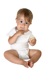 Baby boy sitting up and eating a sandwich