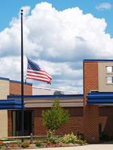 A Flag Flying Half Mast Over A Brick Building