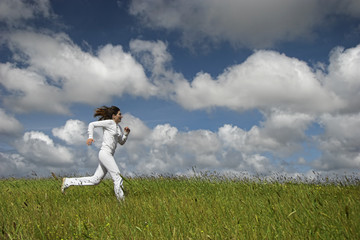 Wall Mural - Bautiful woman running on a green meadow