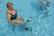  Frau beim Radfahren unter Wasser