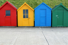 A Row Of Four Similar, But Different, Beach Huts.