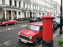 London, Red Mail Box And Red Cars On A Rainy Street