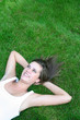© pikselstock - Young woman lying on a lawn