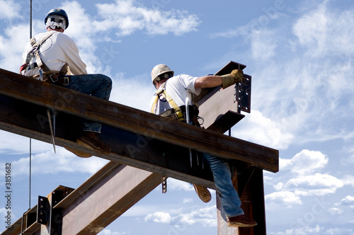 Fotografie, Obraz Two ironworkers atop the skeleton of a modern building